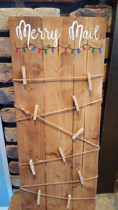 a wooden board with clothes pins attached to it and merry mail written on the front