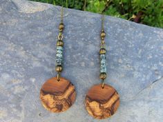 1 Pair of beautiful handmade long and light round Earrings in fine olive wood and long genuine African turquoise beads Diameter 2,5 cm ( 0.98 inch ) Total Lengths of the earrings ~ 7.5 cm ( 2.95 inch ) The unusual ear hooks are bronze plated naturally the grain of the olive wood can vary from item to item , but in any case you will get a pair of olive wood earrings with beautiful grain. You can find more olive wood earrings ,rings , bracelets and necklaces in our shop ! Handmade in Portugal Bohemian Jewelry With Natural Wood Round Beads, Bohemian Jewelry With Wooden Beads, Bohemian Natural Wood Jewelry As Gift, Bohemian Round Natural Jewelry, Bohemian Natural Wood Jewelry Gift, Artisan Natural Wood Jewelry With Wooden Beads, Artisan Wooden Beads Jewelry In Natural Wood, Bohemian Earrings With Wooden Beads, Bohemian Wooden Bead Earrings In Natural Color