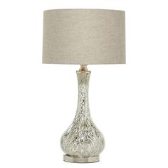 a glass table lamp with a beige shade on it's base and a white linen lampshade