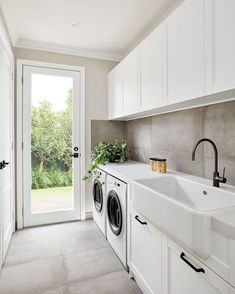 a washer and dryer in a white laundry room with doors leading to the outside