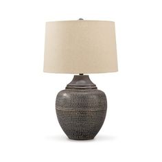 a table lamp with a white shade on it and a black vase in the middle