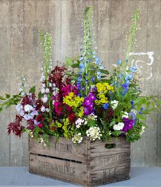 flowers in wooden crates are arranged on the table and placed next to eachother