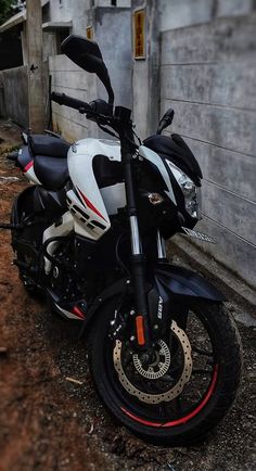 a white and black motorcycle parked next to a building