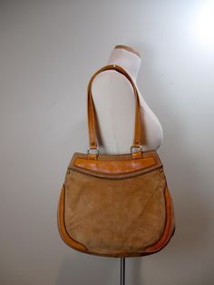 1970s shoulder bag features a tan suede exterior with genuine leather trim, hidden snap closure, unlined interior with two vinyl zippered pockets and double shoulder straps.  SIZING: ✦✦Width: 12" ✦✦Depth: ~3-1/2" ✦✦Height: 10" ✦✦Strap drop: 11" The bag shows age related wear including soiling to the suede, primarily on the bottom and sides as shown. BAGS: www.etsy.com/shop/BeehiveBoutiques?ref=l2-shopheader-name%C2%A7ion_id&section_id=18372021 BEEHIVE BOUTIQUE: www.etsy.com/shop/BeehiveBoutiques MORE INFO: www.etsy.com/shop/BeehiveBoutiques?ref=hdr_shop_menu#more-section Vintage Tote Hobo Bag For Errands, Vintage Satchel Hobo Bag For Errands, Vintage Shoulder Bag With Leather Trim For Shopping, Vintage Beige Hobo Bag, Retro Brown Shoulder Bag For Errands, Retro Brown Satchel For Errands, Vintage Shoulder Bag With Leather Handles For Errands, Vintage Beige Hobo Bag For Shopping, Everyday Vintage Bags With Leather Trim