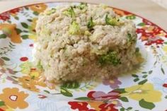 a close up of food on a flowered plate with broccoli and meat