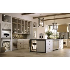 a kitchen with white cabinets and an island in the middle, surrounded by wood flooring