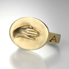 This 10K yellow gold Gabriella Kiss ring is a part of her coveted 'Love  Token' series.  It features a beautifully detailed carved hand, with the  Latin  word "AMICITIA" meaning "Friendship", inscribed on the band.<br><br>Gold disc measures 14.2mm x 19mm<br>Size 6.75<br><br><a href="http://www.quadrumgallery.com/ring-sizing" style="font-family: tahoma, arial, verdana, sans-serif; font-size: 12px;">RING SIZING OPTIONS</a><br><br><br>Handcrafted in Hudson Valley, NY. <br><br> Gold Hand Ring, Gabriella Kiss, Hudson Valley Ny, Love Token, Gold Disc, Hand Ring, Eye Ring, Gold Hands, Hand Jewelry