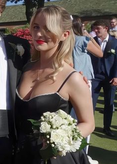 a man in a tuxedo standing next to a woman in a black dress