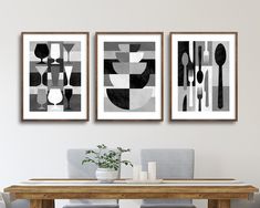 two black and white art prints hanging above a dining room table