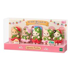 three little toy animals are in a pink box and one is wearing a green dress