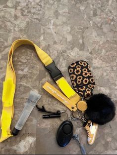 a yellow lanyard with some keys and other items laying on the ground next to it