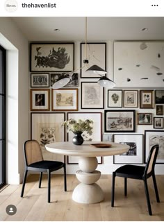 a dining room table with chairs and pictures on the wall in front of it,