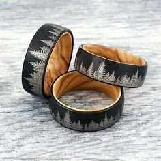 two wooden rings with trees on them sitting on top of a stone floor next to each other