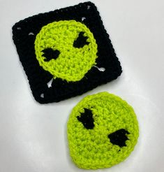 two crocheted smiley faces sitting next to each other