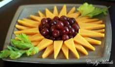 grapes and cheese arranged in the shape of a sun on a plate with lettuce