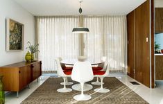 a dining room table with four chairs and a lamp in the middle of the room