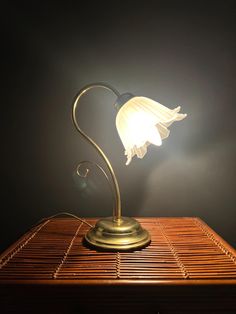 a lamp that is sitting on top of a wooden table next to a black wall