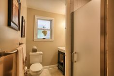 a bathroom with a white toilet sitting next to a window