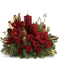 a christmas arrangement with red candles and greenery on a black background in the center