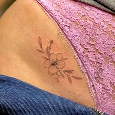 a woman's stomach with a flower tattoo on her lower back and the side