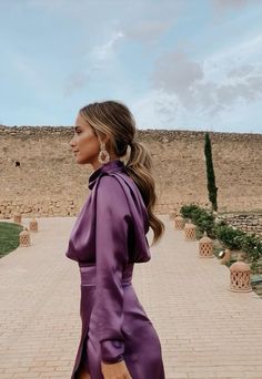 a woman in a purple dress is walking