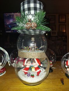 there is a snow globe with santa clause in it on the table next to other ornaments