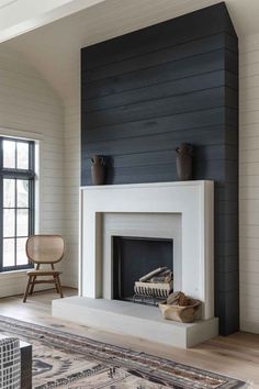 a living room with a white fireplace and black walls