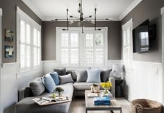 a living room filled with furniture and a flat screen tv mounted to the side of a wall