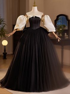 Designed to captivate from every angle, this prom dress is a symphony in black and ivory. The dramatic puff sleeves and delicate off-shoulder neckline frame the wearer in a portrait of vintage sophistication, while the black bodice and skirt promise a night of enchantment. As the skirt fans out in a sea of tulle, it creates an air of mystery that beckons a closer look. This dress is a modern tribute to the bygone era of ballroom waltzes and grandiose galas, perfect for the belle of the ball at any prom. Puff Sleeve Prom Dress, Princess Syndrome, Ballroom Extravaganza, Poofy Dresses, Quinceanera Dresses Black, Uzun Boy, Poofy Skirt, Sleeve Prom Dress, Waltz Dress