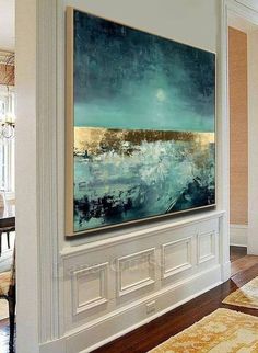 a large painting hanging on the wall in a living room next to a dining room table