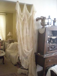 an old fashioned bedroom with white bedding and curtains