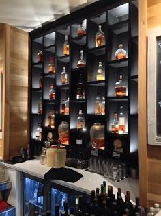 a bar with liquor bottles on the wall and shelves full of alcohol in glass containers