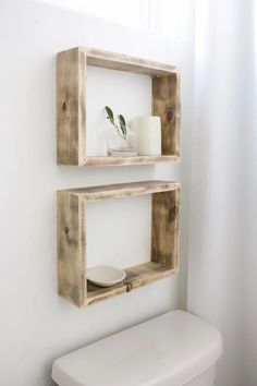 two wooden shelves on the wall above a toilet