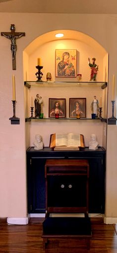 an open book sitting on top of a wooden table next to a shelf filled with pictures and candles