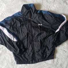 Fila Windbreaker Mens Jacket. Vintage 90s/Y2k Brand New Without Tags (Nwot) This Was All The Rage In The 1990s! Fila Was The Brand!! Men Would Wear Windbreaker Pants And Matching Windbreaker Jackets. This Is Black, White And Dark Teal. The Size Is A Medium. Excellent Condition As It Has Never Been Worn! 80s/2000s/Y2k Vintage Black Long Sleeve Outerwear, Black Vintage Long Sleeve Outerwear, 90s Style Black Outerwear For Spring, Retro Black Track Jacket With Pockets, Vintage Black Windbreaker For Sports, Black Retro Windbreaker, Black Long Sleeve Retro Windbreaker, Vintage Black Sports Windbreaker, Retro Black Hooded Track Jacket