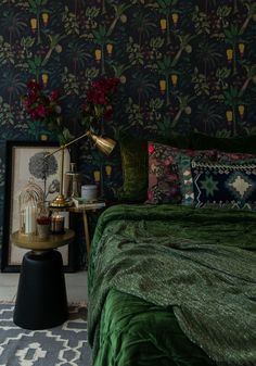 a bedroom with green bedding and wallpaper