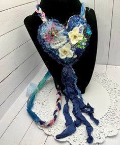 a mannequin with flowers and ribbons on it next to a lace doily