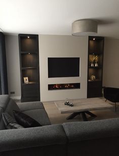 a living room filled with furniture and a flat screen tv mounted on the wall over a fire place