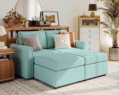 a living room with a blue couch and some pillows on the floor in front of a mirror