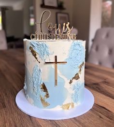 a cake decorated with blue and gold icing on top of a wooden table in a living room