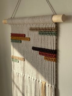 the wall hanging is made out of yarn and wooden dows, which are colored with different colors