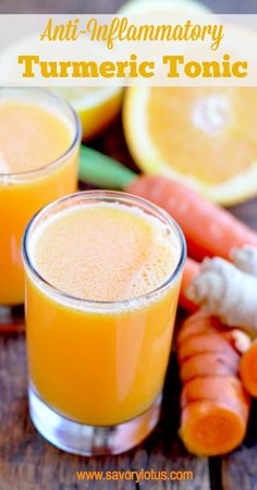 two glasses filled with orange juice next to carrots and celery