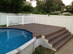 an above ground pool with steps leading up to the deck and swimming pool in the back yard