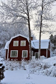 a red barn with snow on the ground and trees