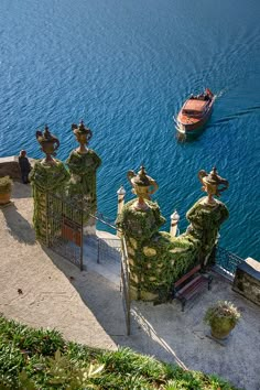 a boat is in the water next to some buildings with statues on it's sides