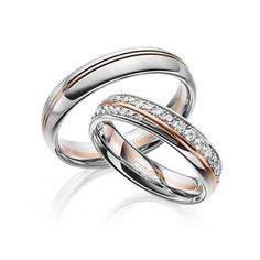 two white and rose gold wedding rings with diamonds on each band, set against a white background