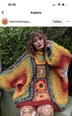 a woman sitting on top of a bench wearing colorful crocheted sweater and leggings