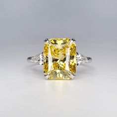 a fancy yellow diamond ring with three diamonds