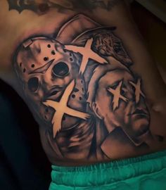 a man with a tattoo on his stomach wearing a hockey mask and holding a cross