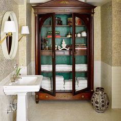 a bathroom with an armoire and sink in it